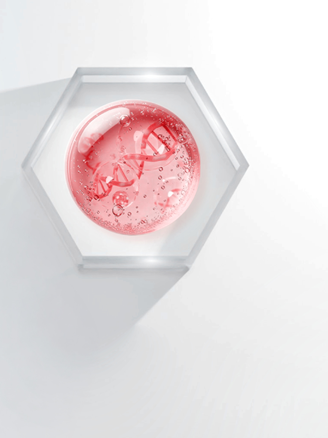 A drop of pink PDRN gel with visible DNA strands on a glass hexagon